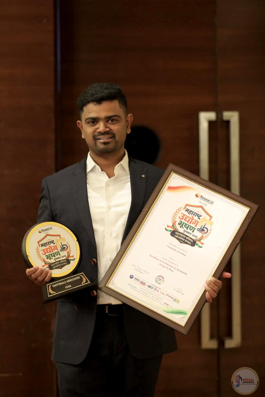 Er. Rushikesh Pingale holding the Maharashtra Udyog Bhushan Award 2026 trophy and certificate presented to Vastukala Associates